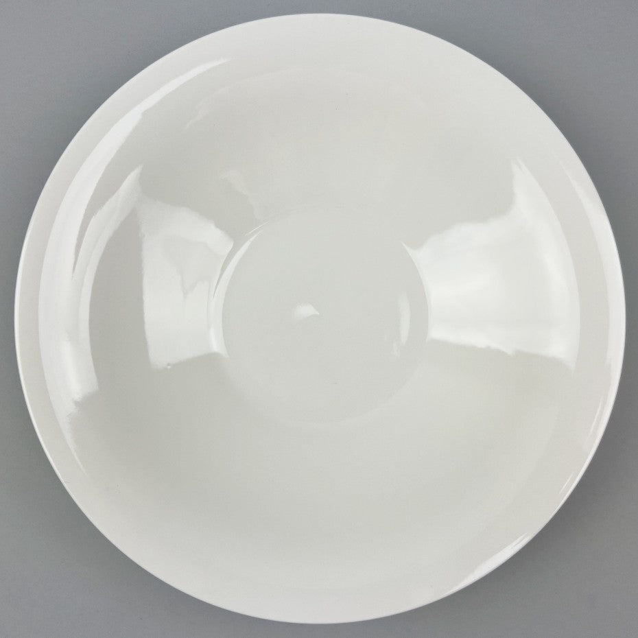 White ceramic shallow bowl with a deep pasta plate on a gray background, shot from the top.